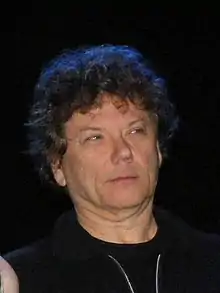 close-up of Jerry Harrison wearing a dark sleeveless top, looking left of camera with a set facial expression