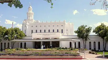 The St. George temple in the background, with the visitors' center in the foreground a garden can be seen in the front.